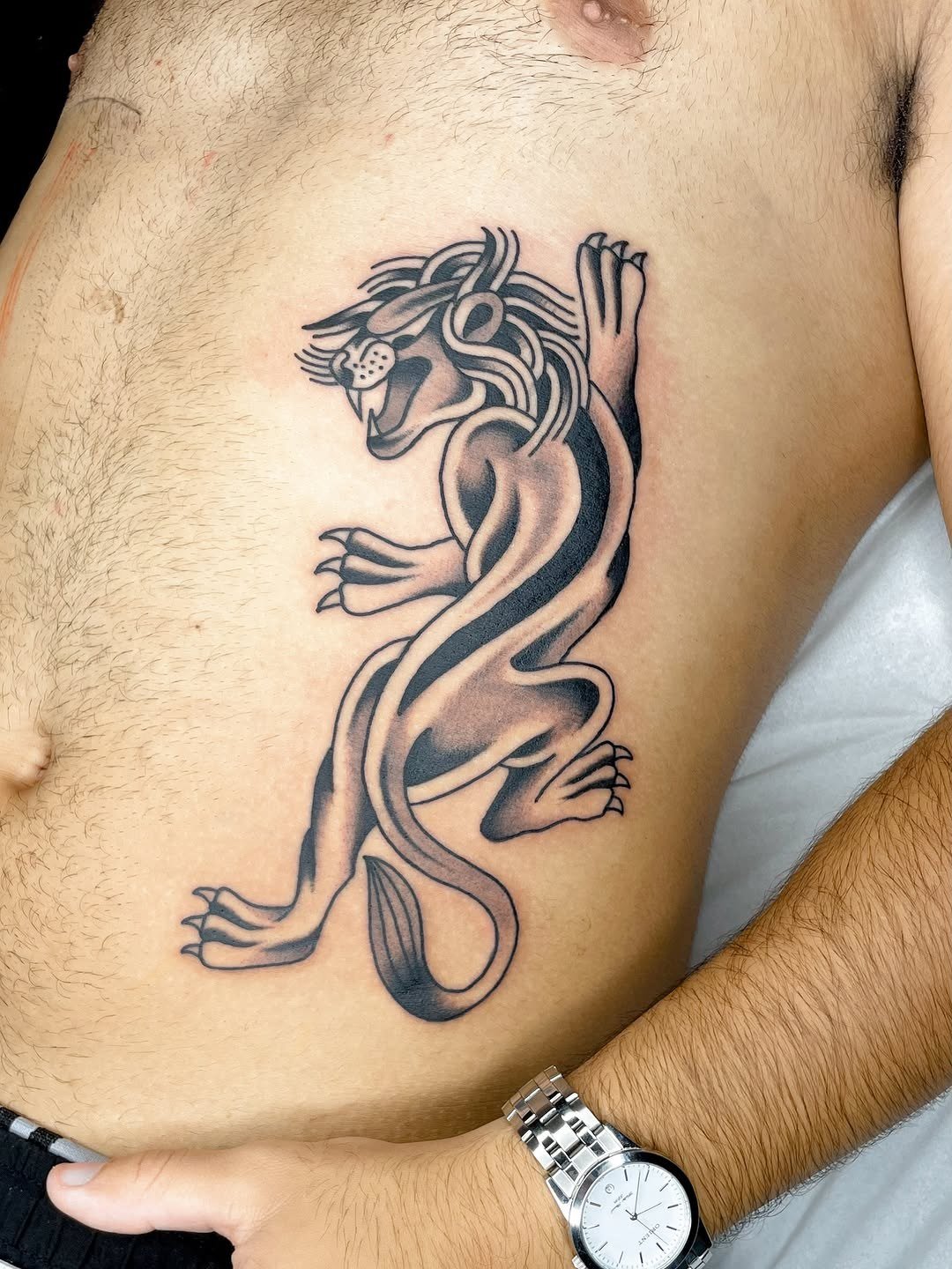 Pantera a preto tatuada na lateral do tronco